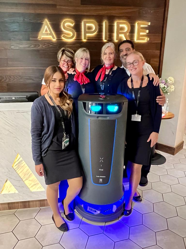 The Aspire Front of house team at a UK airport gathered around Holabot on the first day at work.